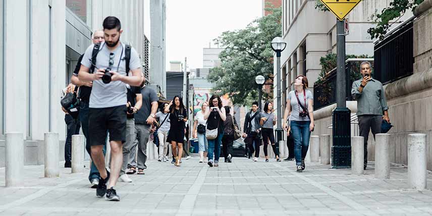 Image of people walking in street distracted by digital devices
